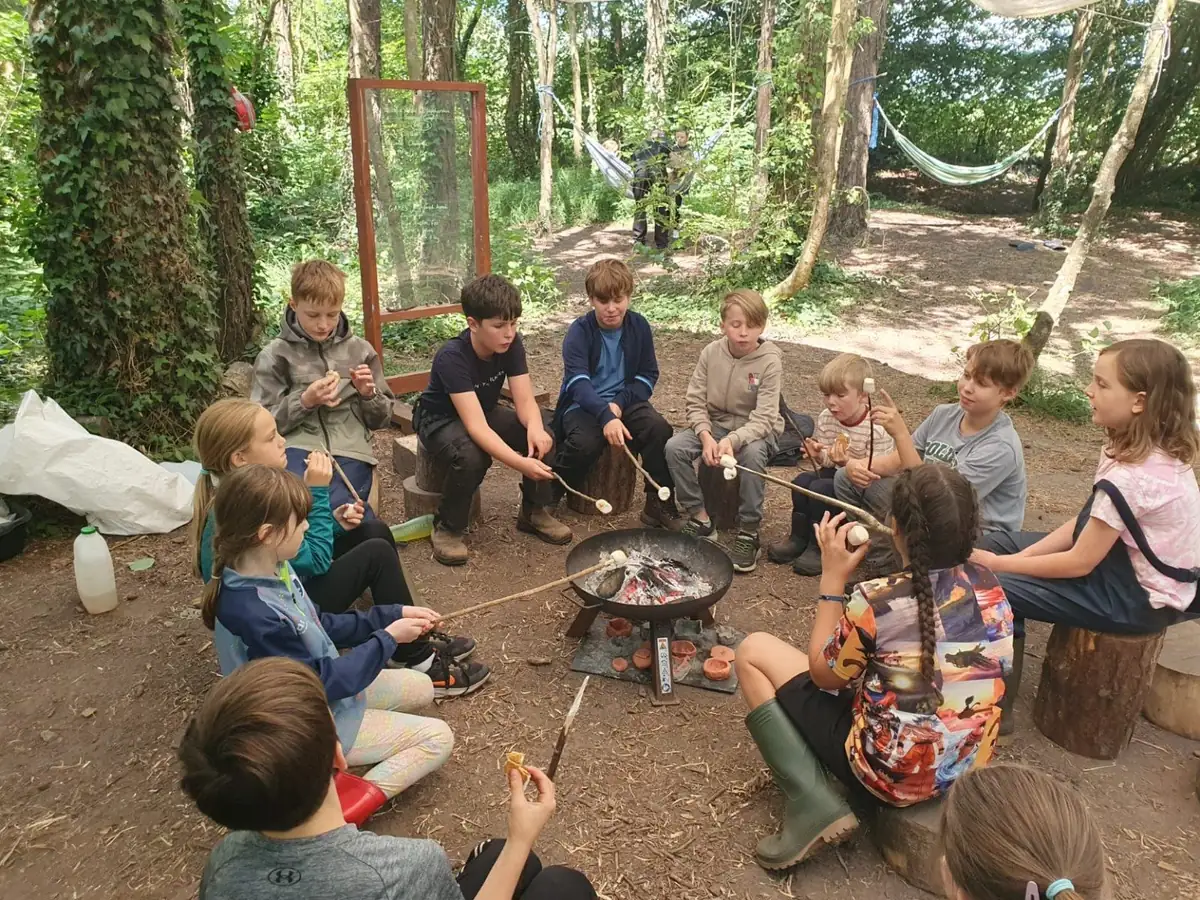 Children taking part in a woodland rope challenge at Forest School Cloughjordan